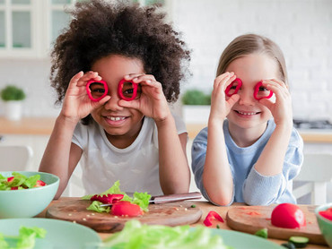 Bunte Salate sind eine leckere vegane Rezeptidee für Kinder. Kinder mit Gemüse für einen veganen Salat.