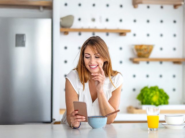 Frau mit Smartphone in Küche Frau mit Smartphone in Küche
