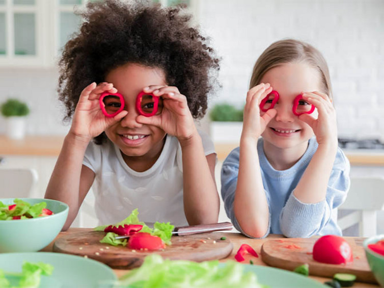 Bunte Salate sind eine leckere vegane Rezeptidee für Kinder. Kinder mit Gemüse für einen veganen Salat.
